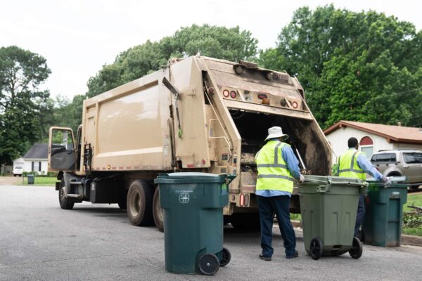 Trash Removal Services in Kent, WA – A Complete Guide Sanitation workers providing trash removal services Kent WA, loading garbage bins into a disposal truck on a suburban street.