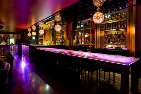 The Allure of a Cocktail Lounge: A Complete Insight Elegant cocktail lounge with dim lighting, stylish seating, and a bartender preparing signature drinks, creating a luxurious and sophisticated nightlife atmosphere.