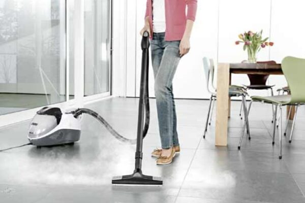 Professional Apartment and Condo Cleaning Services in Fuquay Varina, NC Woman using a steam cleaner on tiled flooring as part of Professional Apartment and Condo Cleaning Services in Fuquay Varina, NC.