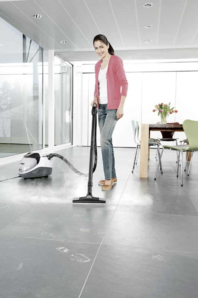 Woman using a steam cleaner on tiled flooring as part of Professional Apartment and Condo Cleaning Services in Fuquay Varina, NC.