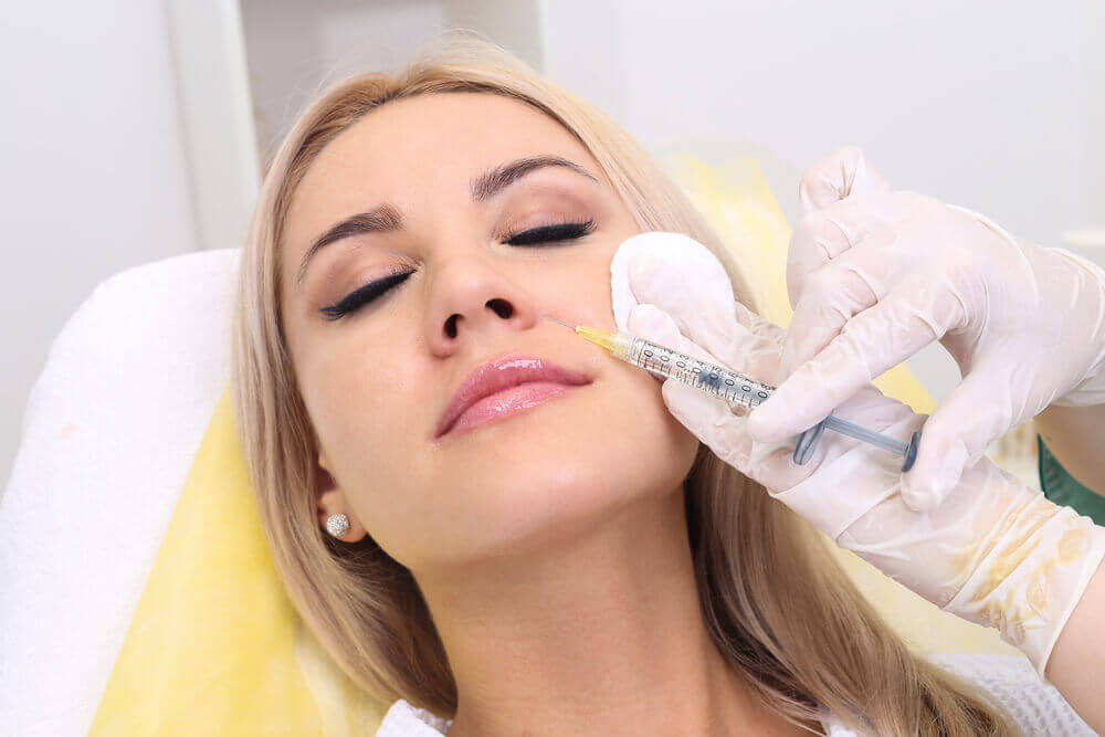 A woman receiving a dermal filler treatment at a med spa offering Rejuvenating Chevy Chase services for smoother, youthful skin.